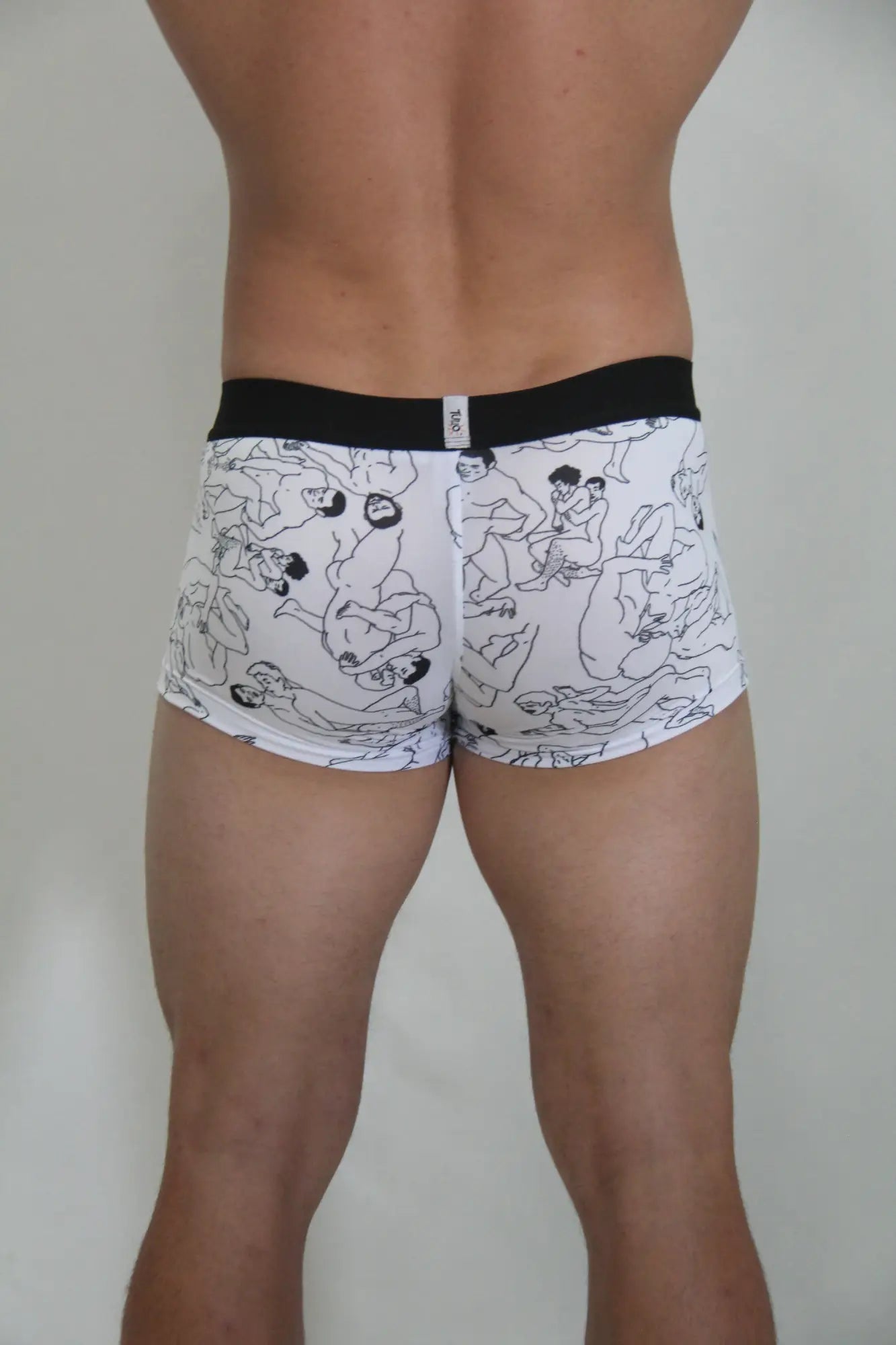 White boxer briefs with black line drawings of figures and a solid black waistband from gay karmasutra trunk collection