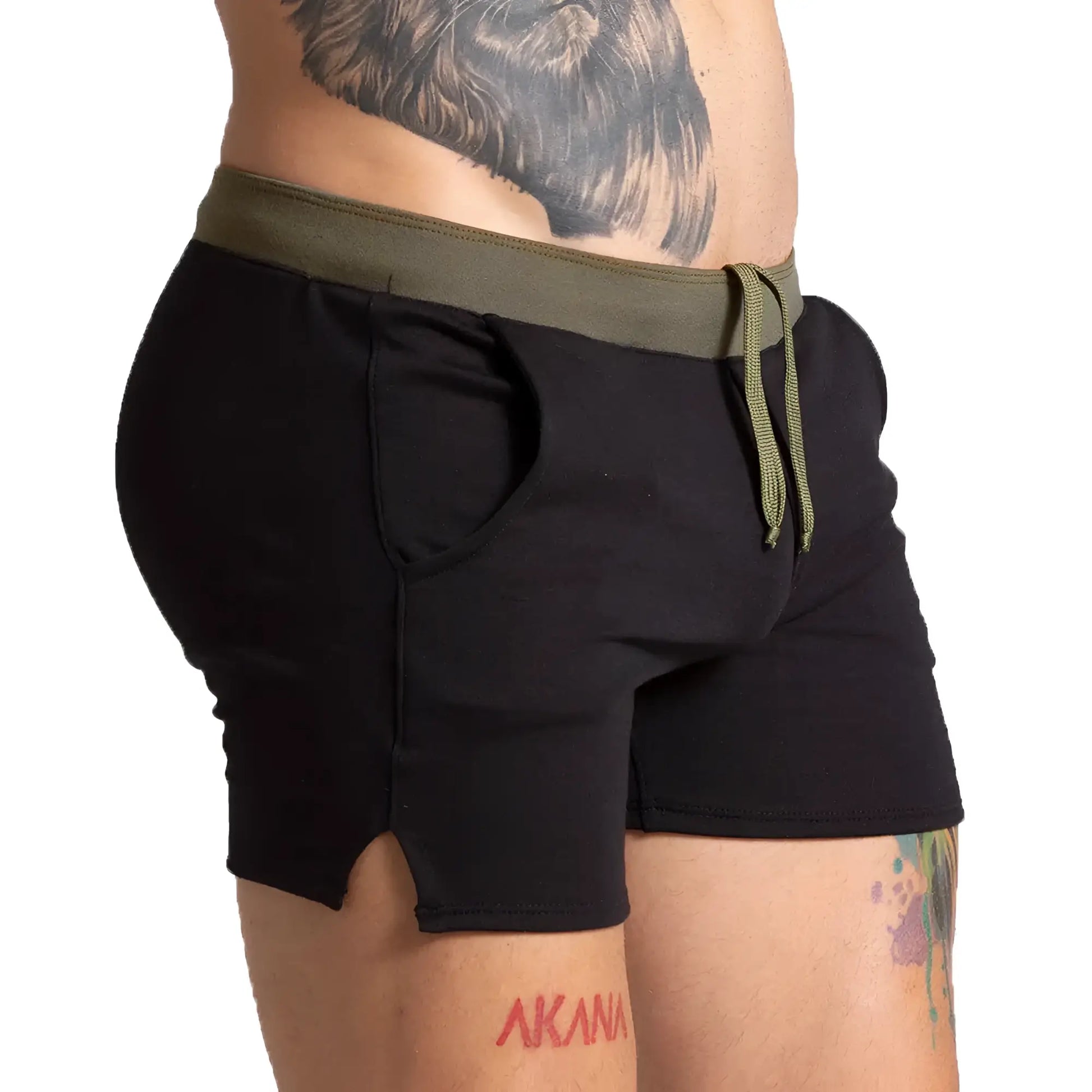 Black athletic shorts with olive green elastic waistband and drawstring side pockets and hem split
