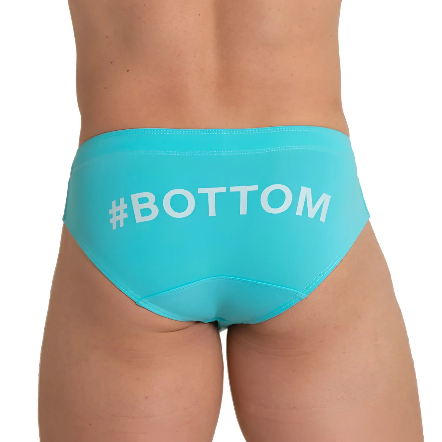 Back view of turquoise gigo bottom blue swim brief swim trunks with white bottom text printed across the back