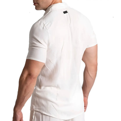 White short-sleeved collared gigo chalis beige shirt with subtle black tag at neckline made from breathable fabric