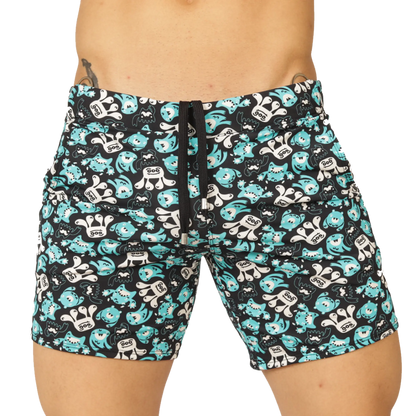 Black swim trunks from gigo comics beachwear with teal and white cartoon monsters featuring goo on chests