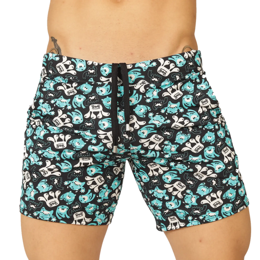 Black swim trunks from gigo comics beachwear with teal and white cartoon monsters featuring goo on chests