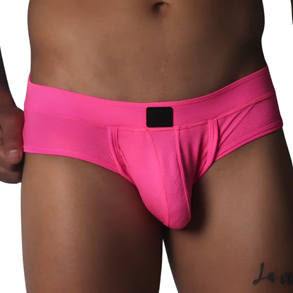 Fuchsia-colored low-rise briefs in textured mesh fabric with a centered black logo patch on the waistband.