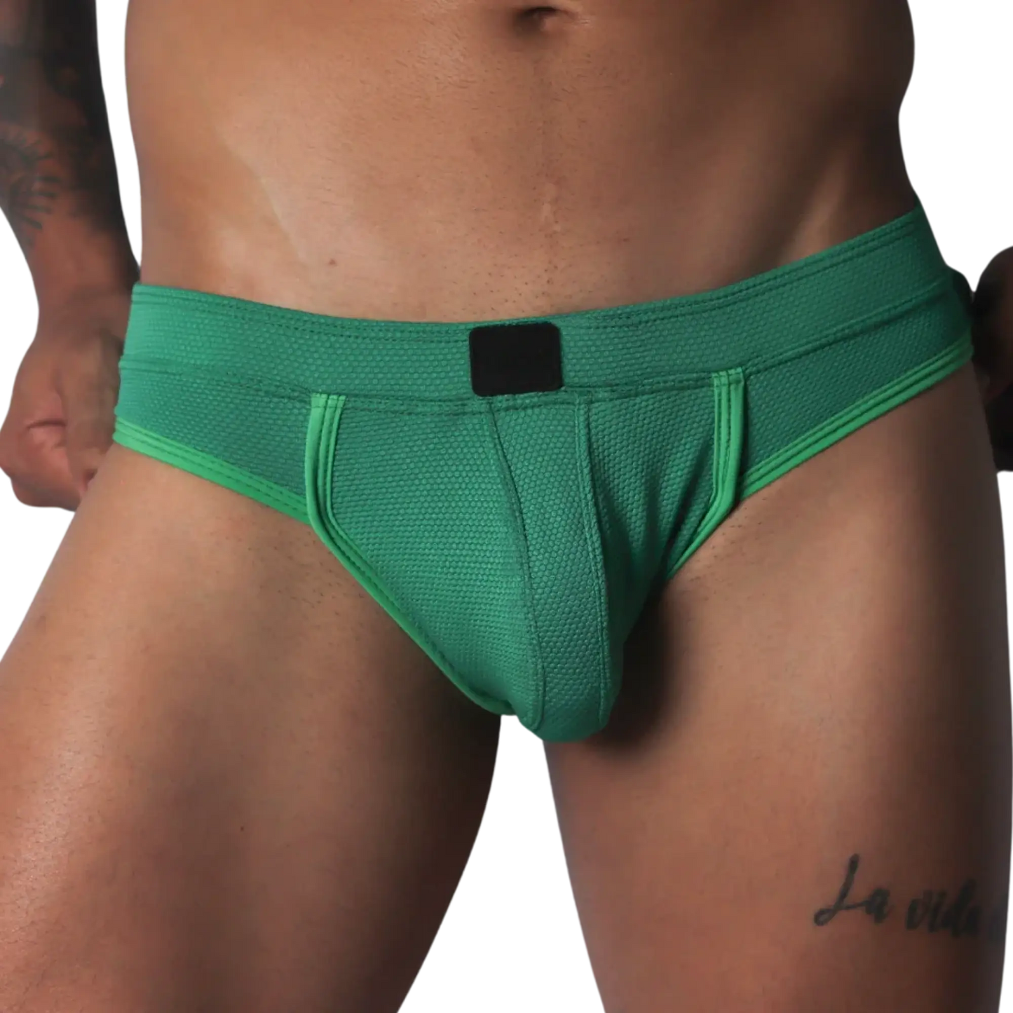 Green jockstrap featuring a textured honeycomb fabric, wide waistband, and a solid black central logo patch.