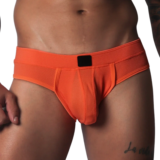 Bright orange athletic jockstrap made of textured honeycomb fabric with a solid black center label on the waistband.