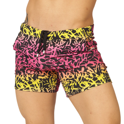 Gigo Crazy Beachwear vibrant graffiti-patterned swim shorts in bold pink yellow and black with drawstring waistband