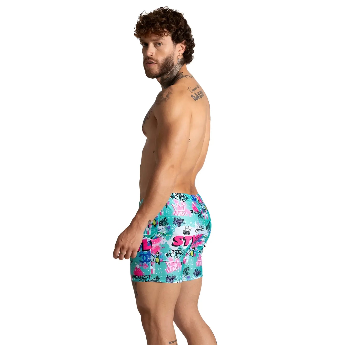 Vibrant turquoise gigo figure beachwear swim trunks with bold pink and purple graffiti style print for summer use