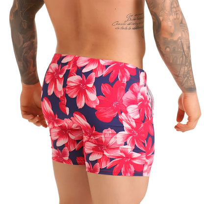 Vibrant pink and white floral patterned swim trunks on navy blue base for gigo flowers fuchsia beachwear