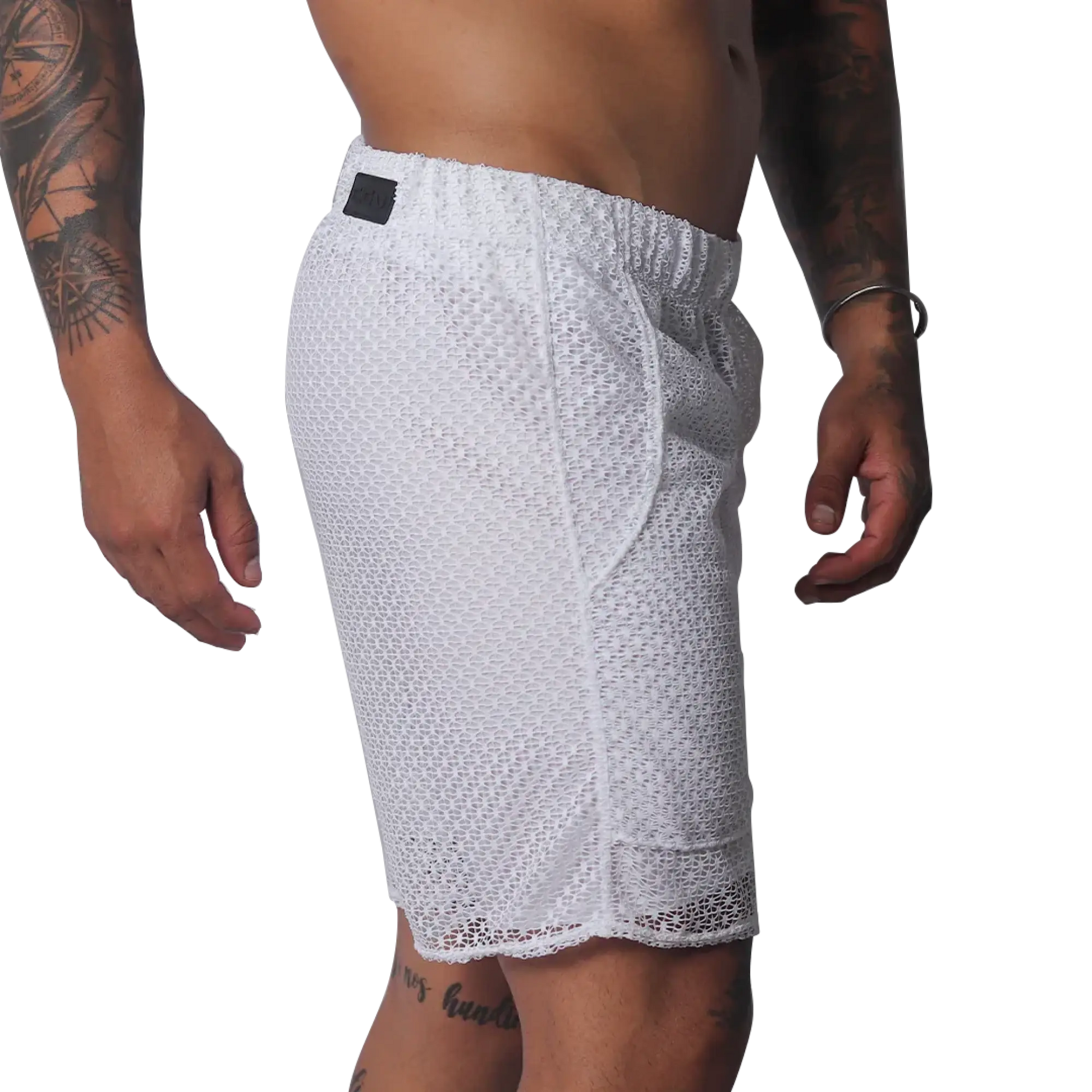 White athletic shorts made of a sheer, open-mesh material with an elastic waistband and small black logo patch.