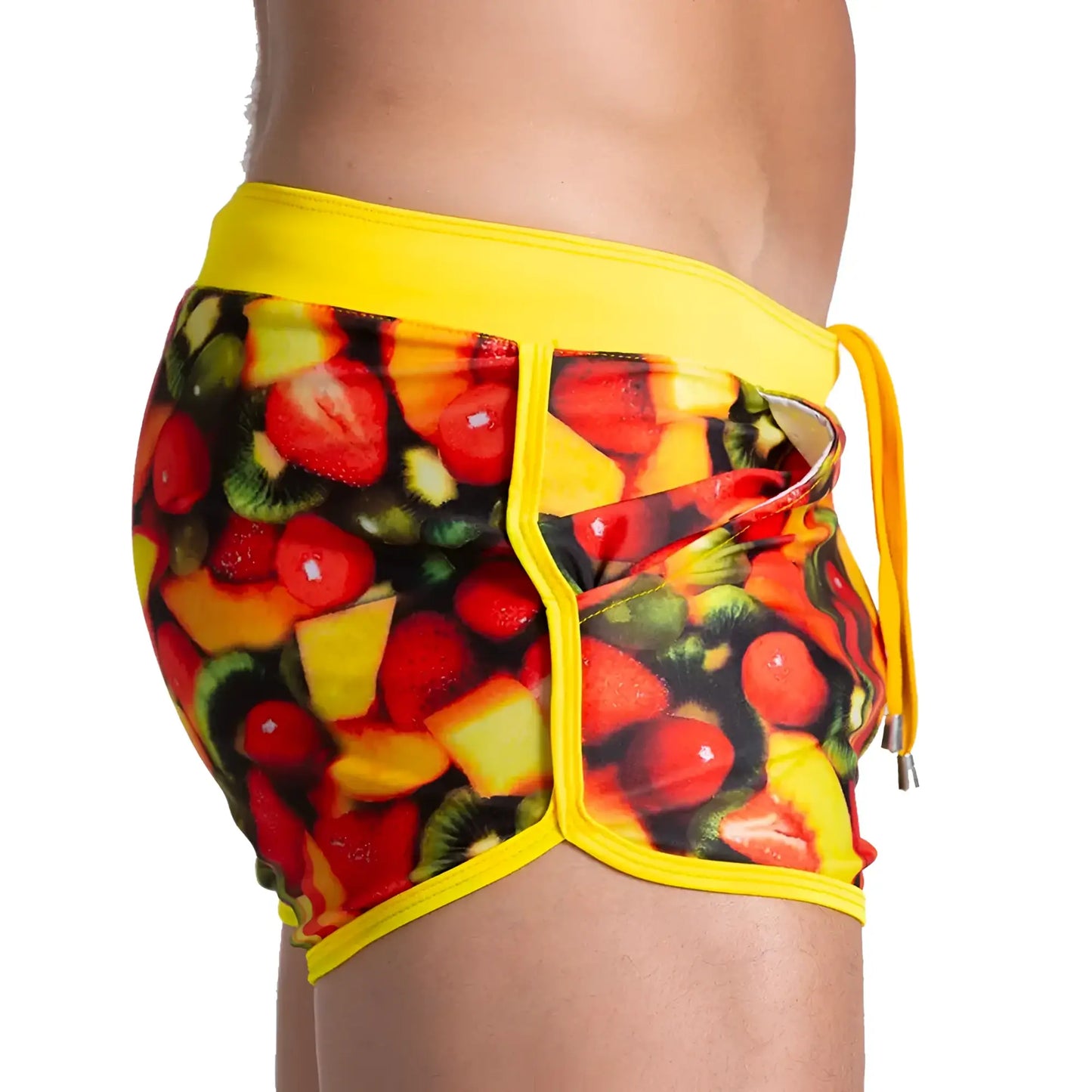Gigo Salad Beachwear vibrant yellow swim trunks with bold colorful strawberry kiwi melon print on dark background