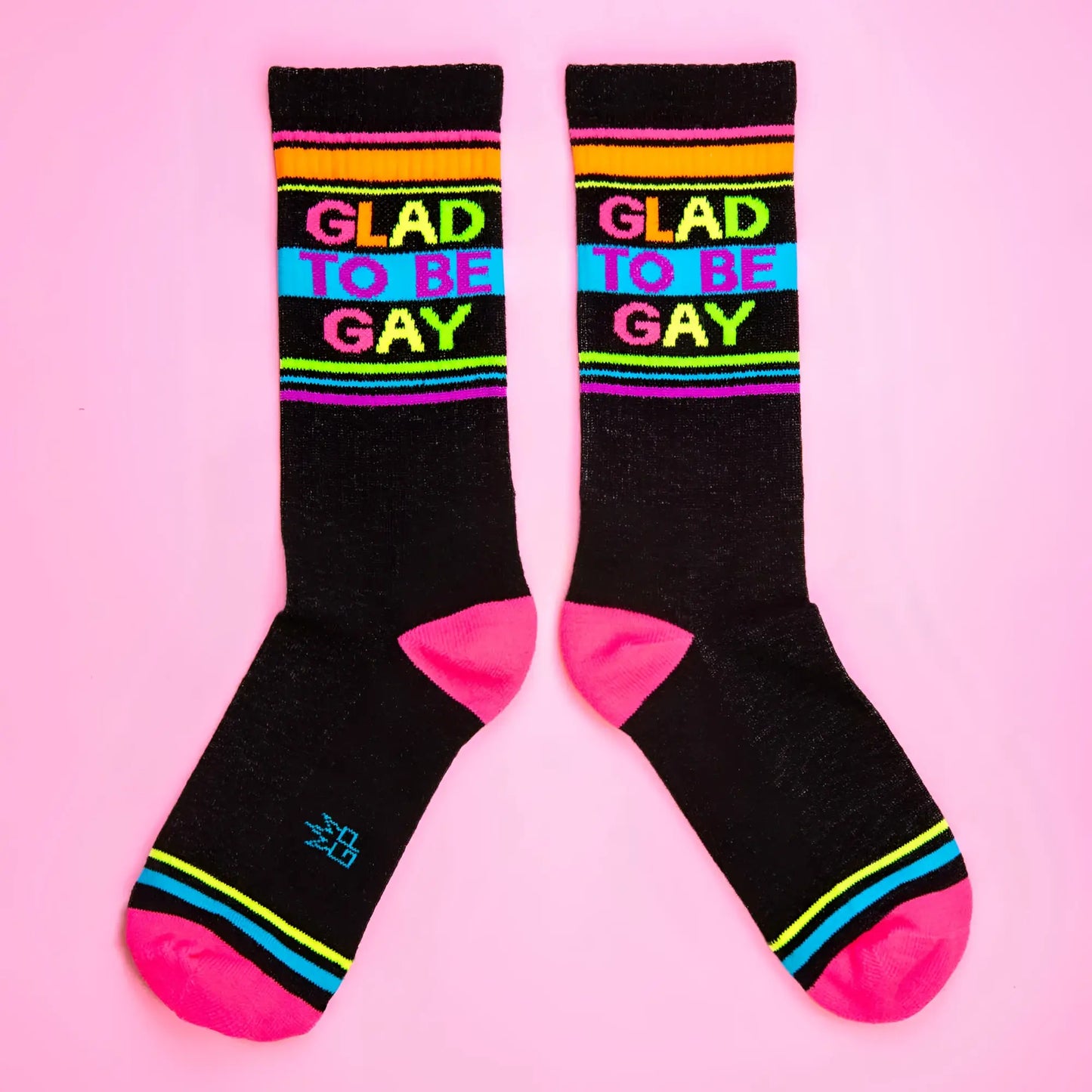 Glad to be gay crew socks with black base rainbow stripes and bold colorful lettering for pride wear