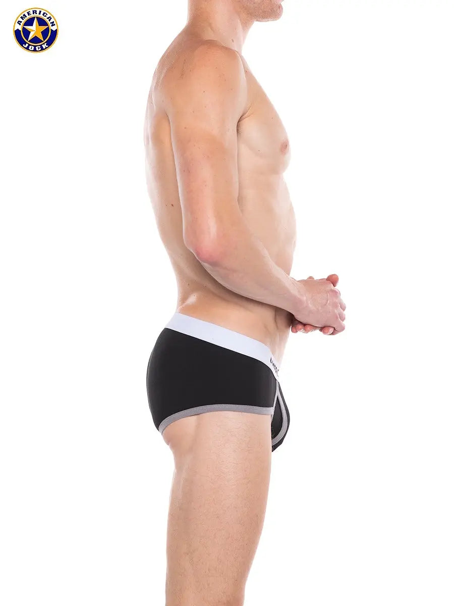 Men's black classic brief with a gray waistband shown on a model from the side by AMERICAN JOCK