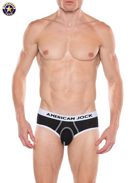 Men's black brief with a white waistband featuring the brand name AMERICAN JOCK worn by a model with a toned physique