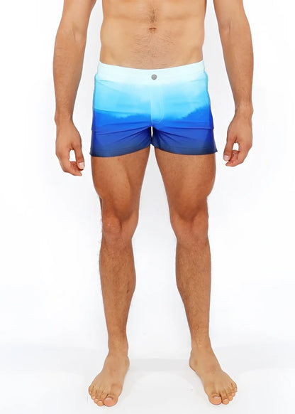 Gradient printed swim shorts with blue ombre pattern and white waistband designed for swimming and beachwear