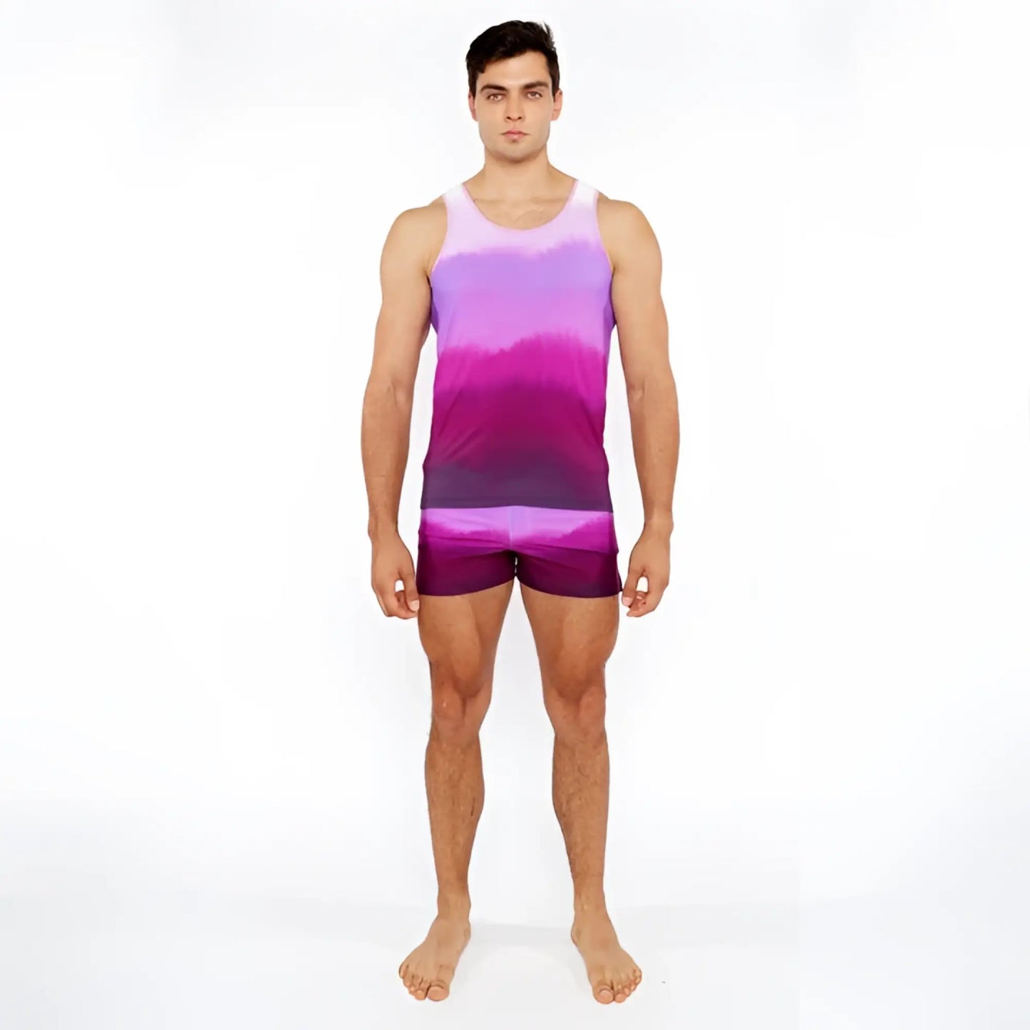 A man wearing a gradient printed swim short and matching tie-dye tank top in purple and pink colors