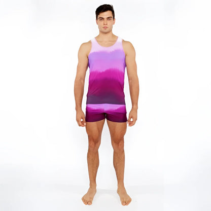 A man wearing a gradient printed swim short and matching tie-dye tank top in purple and pink colors