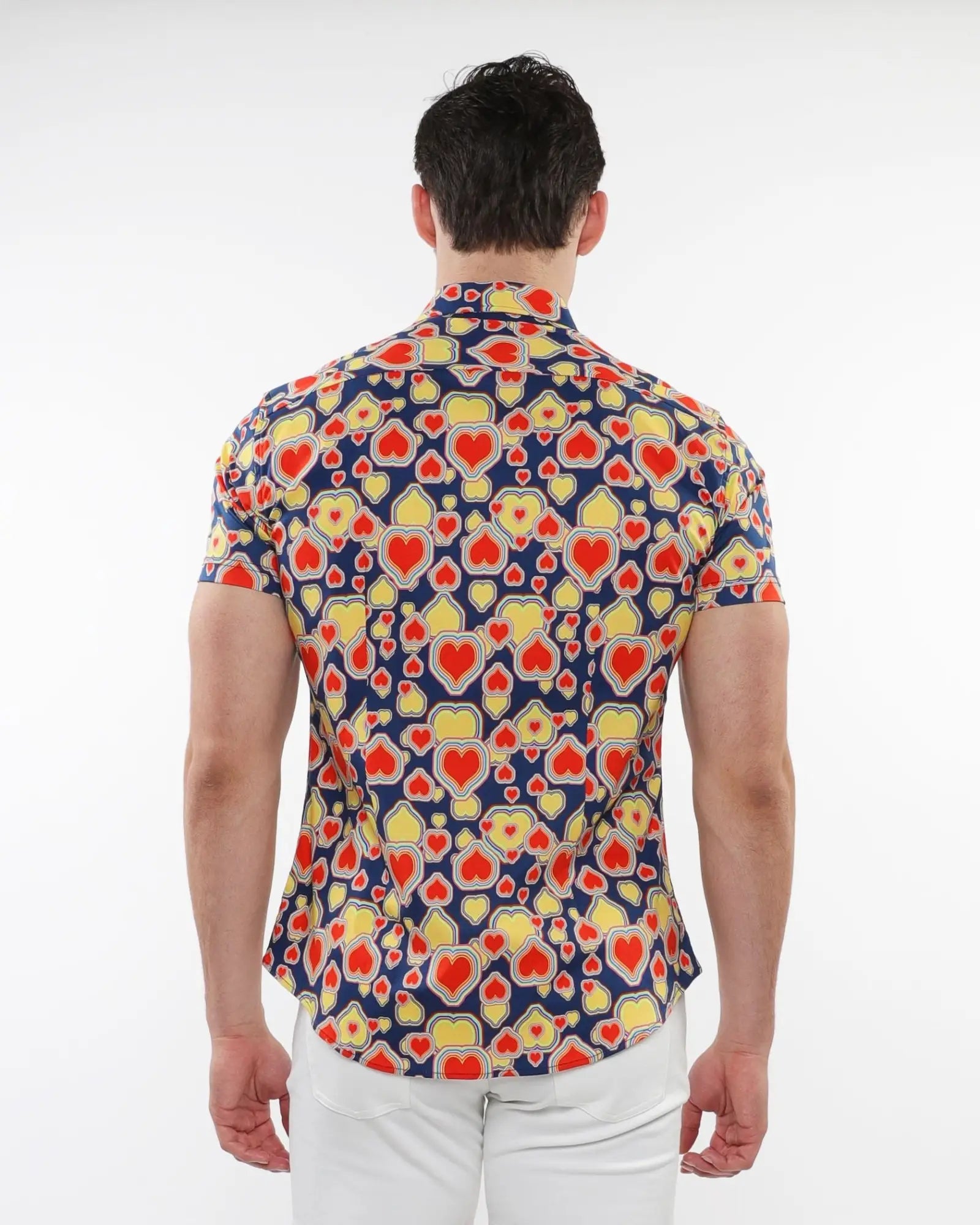 A man wearing a navy blue hearts print stretch knit short-sleeved shirt with red and yellow heart patterns