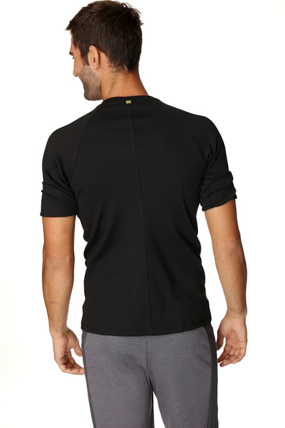 Back view of hybrid crew neck raglan tee black short-sleeved athletic shirt with subtle vertical seam and green logo