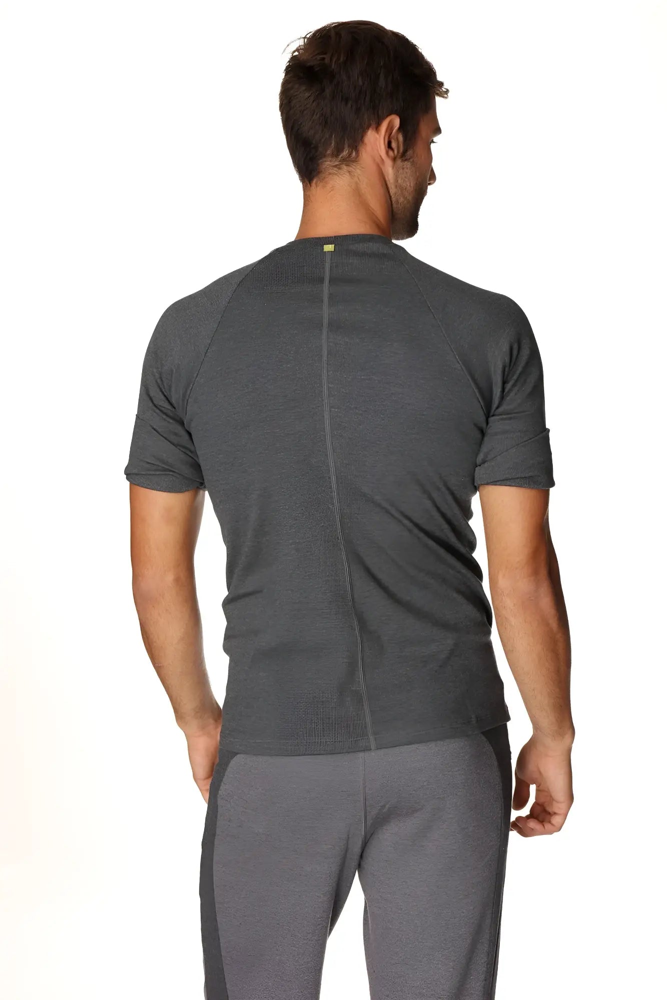 Back view of a dark gray heathered hybrid crew neck raglan tee with a subtle vertical seam for athletic wear