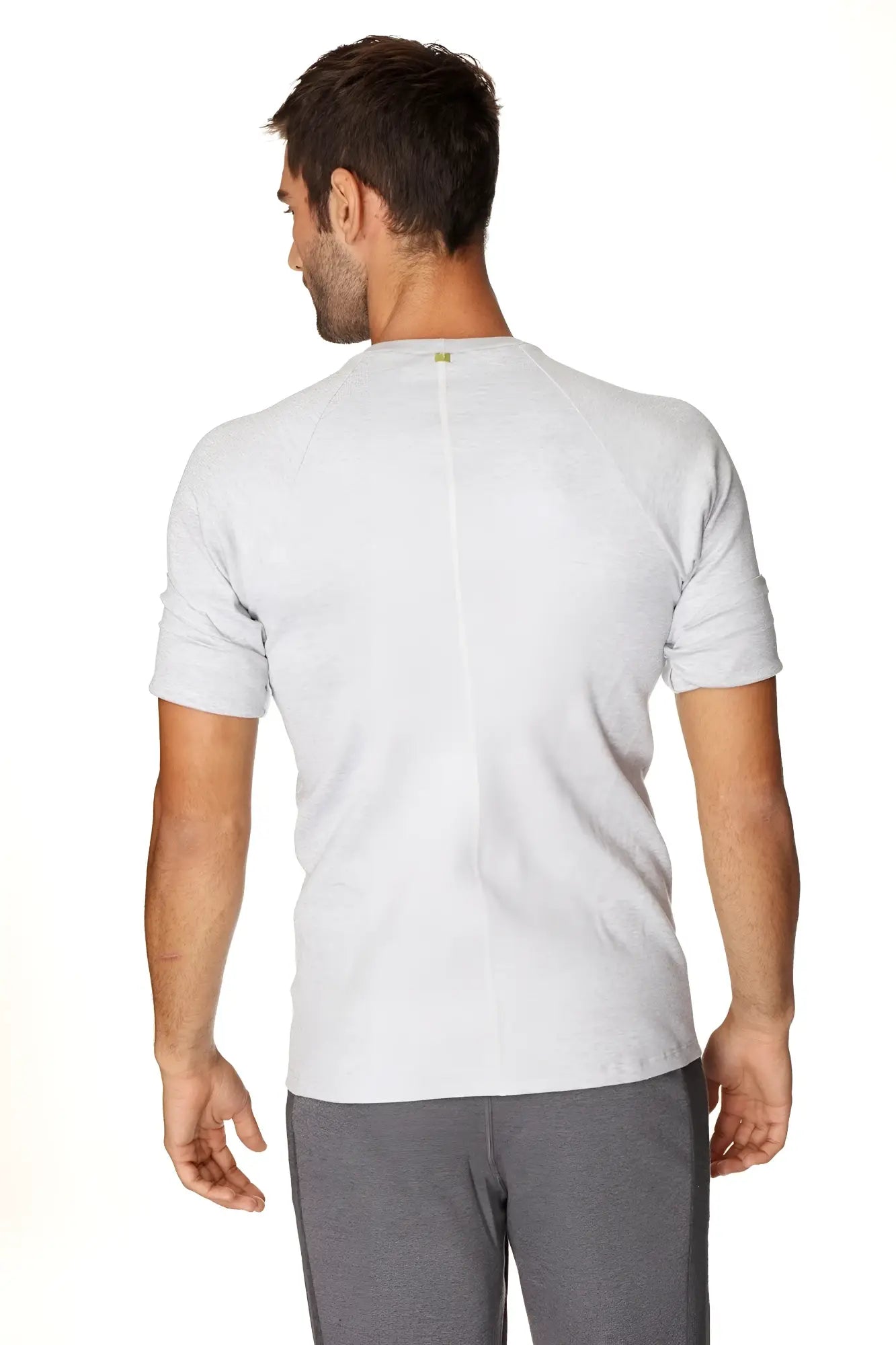 Back view of a gray heathered hybrid crew neck raglan tee with a subtle vertical seam and a small green logo at neckline