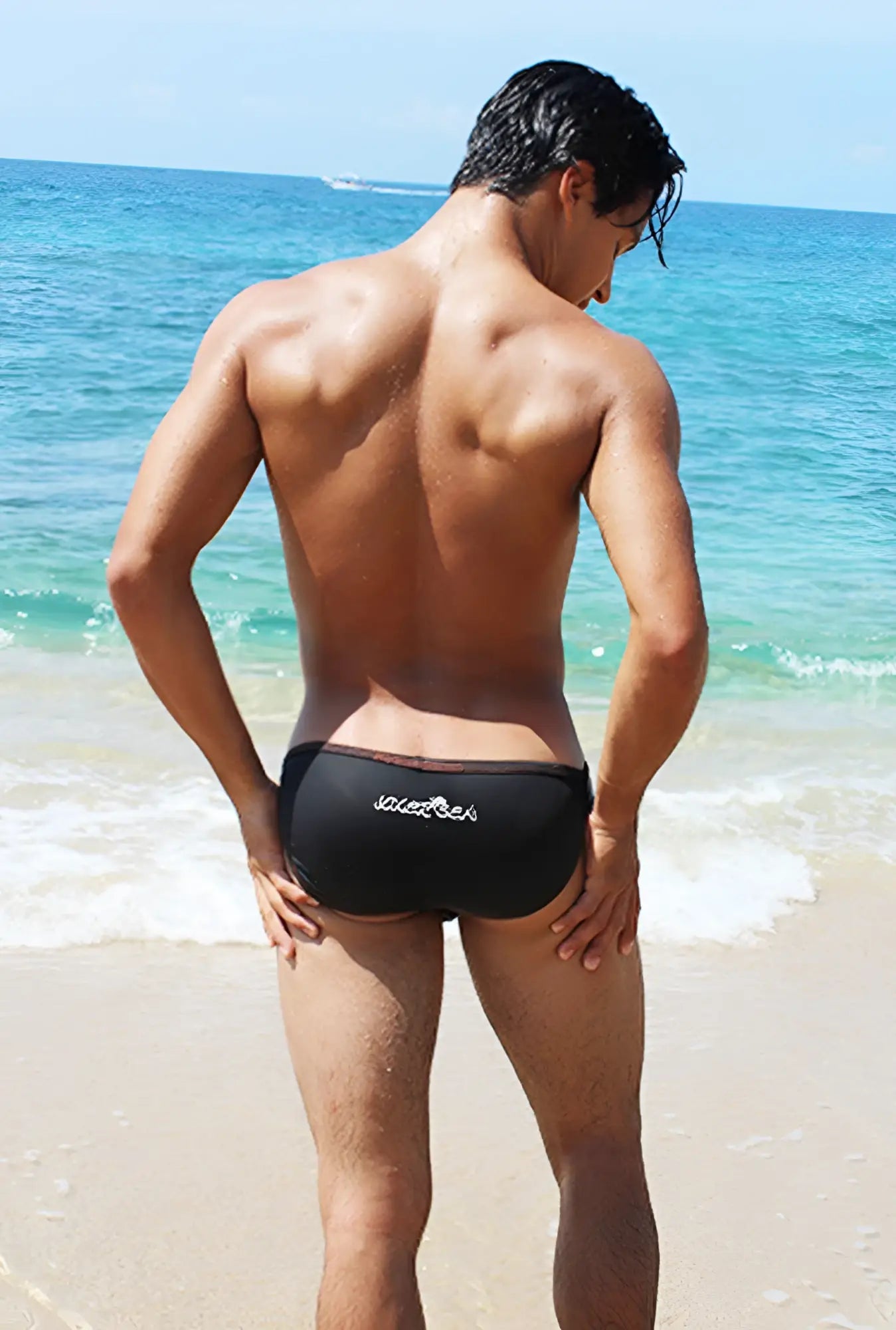 Back view of Icker Sea black swim trunks with subtle white logo contrast stitching micro slip tanga bikini swimwear