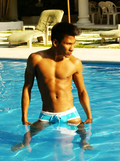 A man standing in a pool wearing icker sea cord contrast trim stitching bikini swimwear in blue and white
