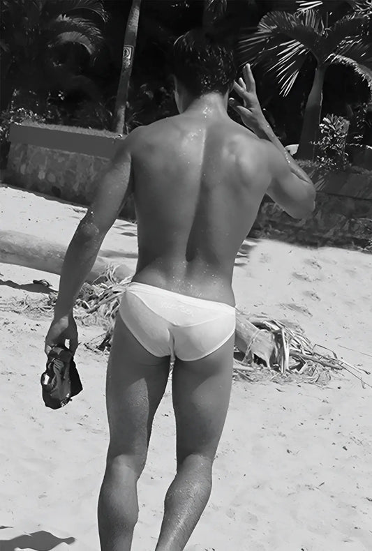 White briefs swimwear by icker sea in duotone blue worn by a man on a beach front view