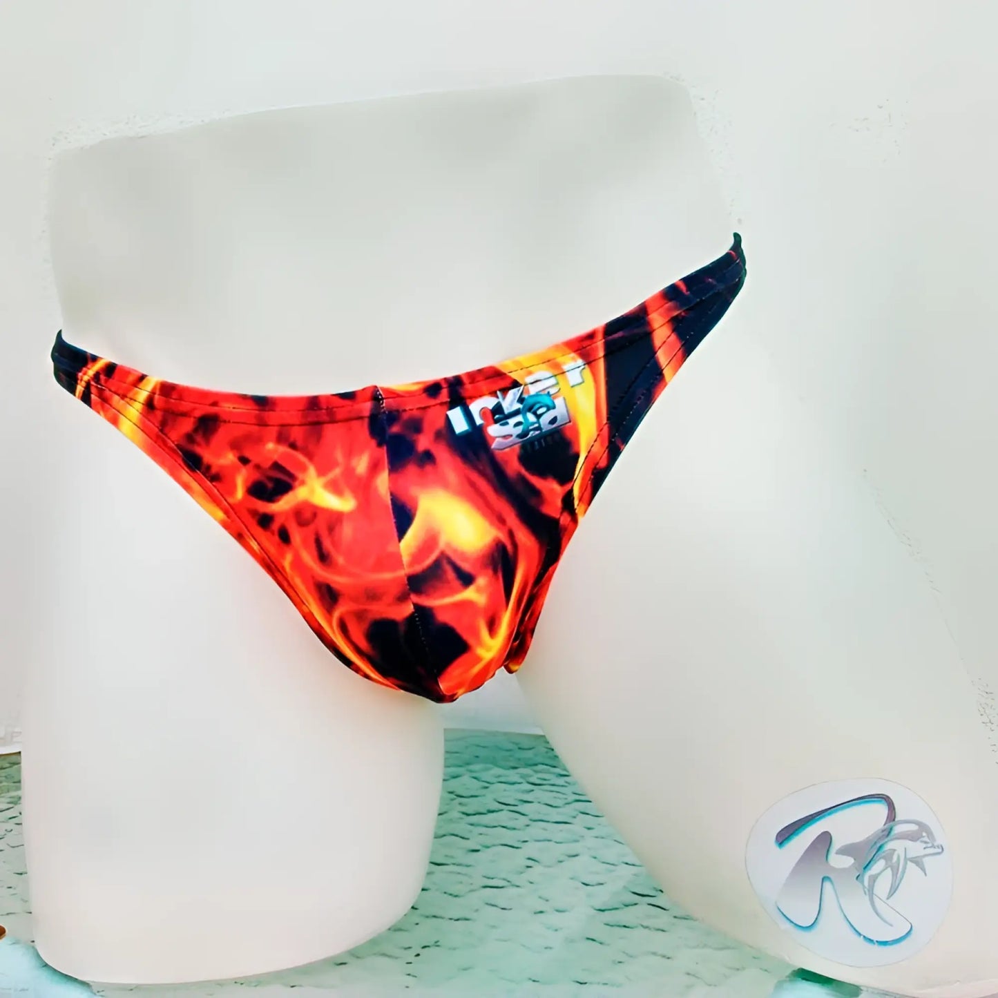 Vibrant red and orange flame-patterned icker sea fire red thong underwear displayed on a mannequin front view