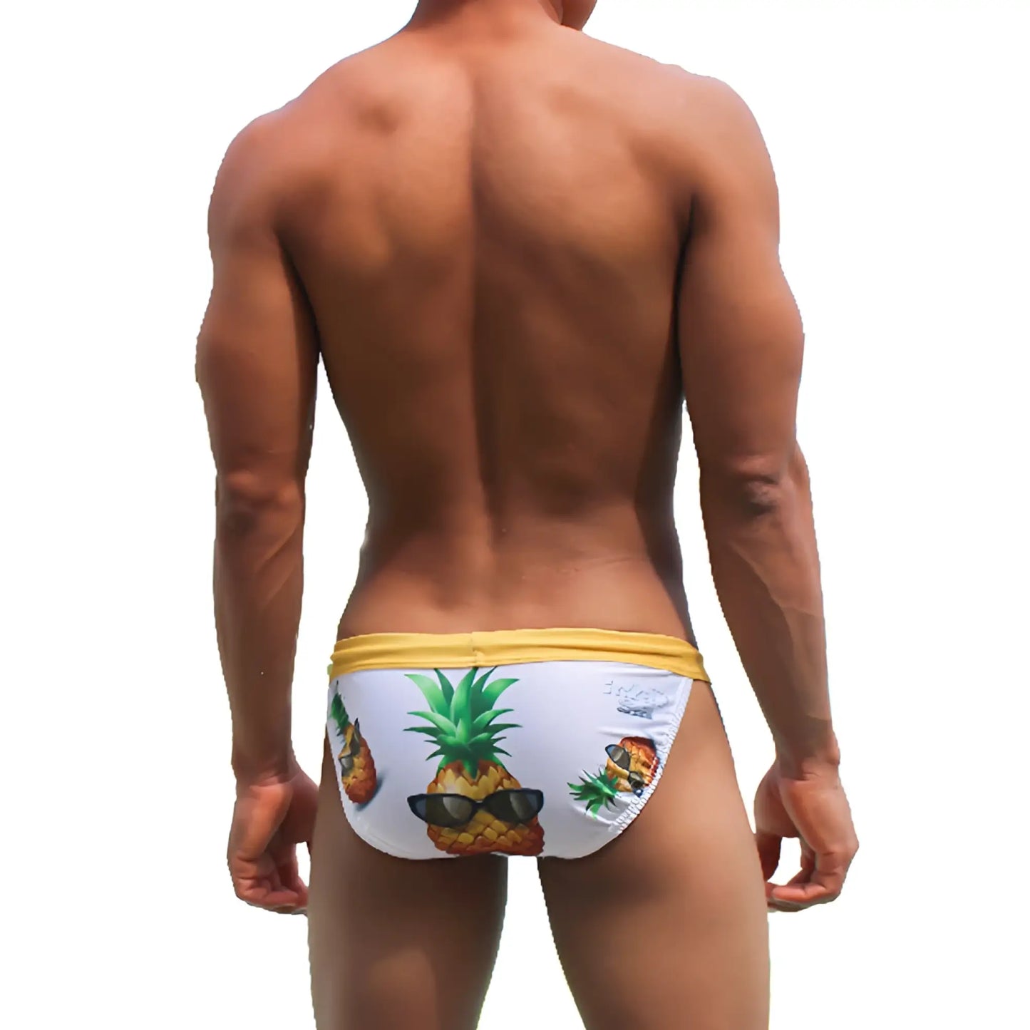 White swim trunks with yellow waistband and playful pineapple graphic wearing sunglasses from icker sea swimwear