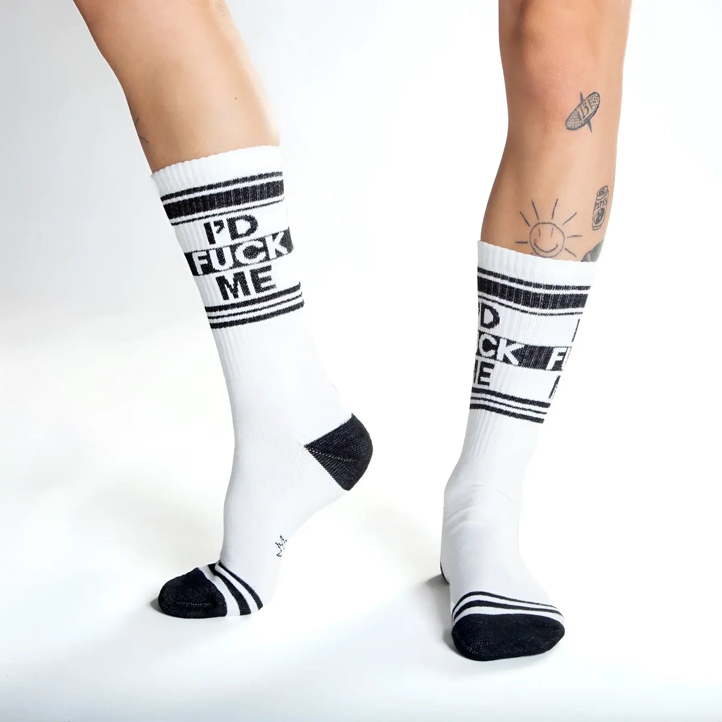White crew socks with black text id fuck me and matching black stripes toe caps and heel accents for casual wear