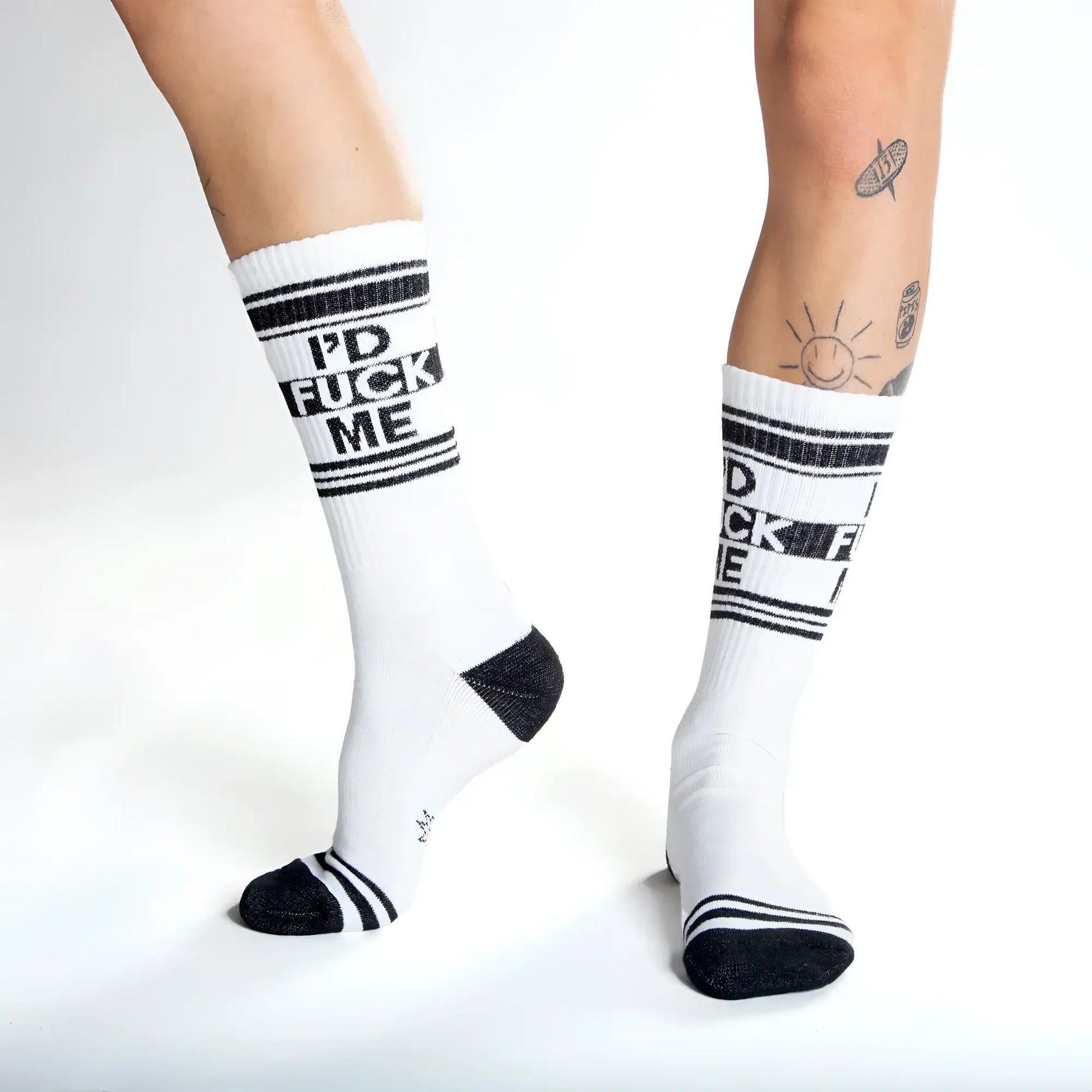 White crew socks with black text id fuck me and matching black stripes toe caps and heel accents for casual wear