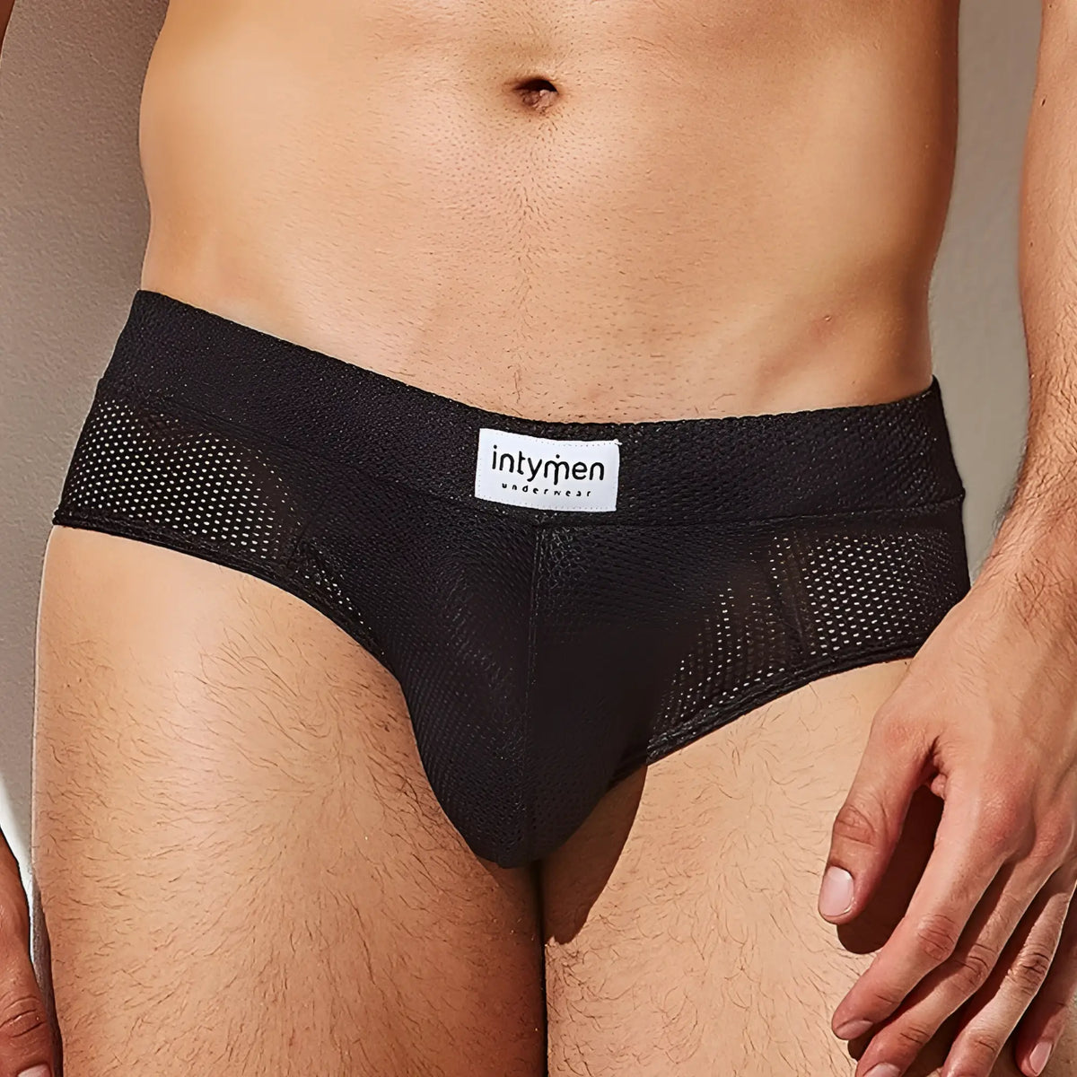 Black mesh briefs with white intymen underwear label on waistband from intymen inj080 brief collection