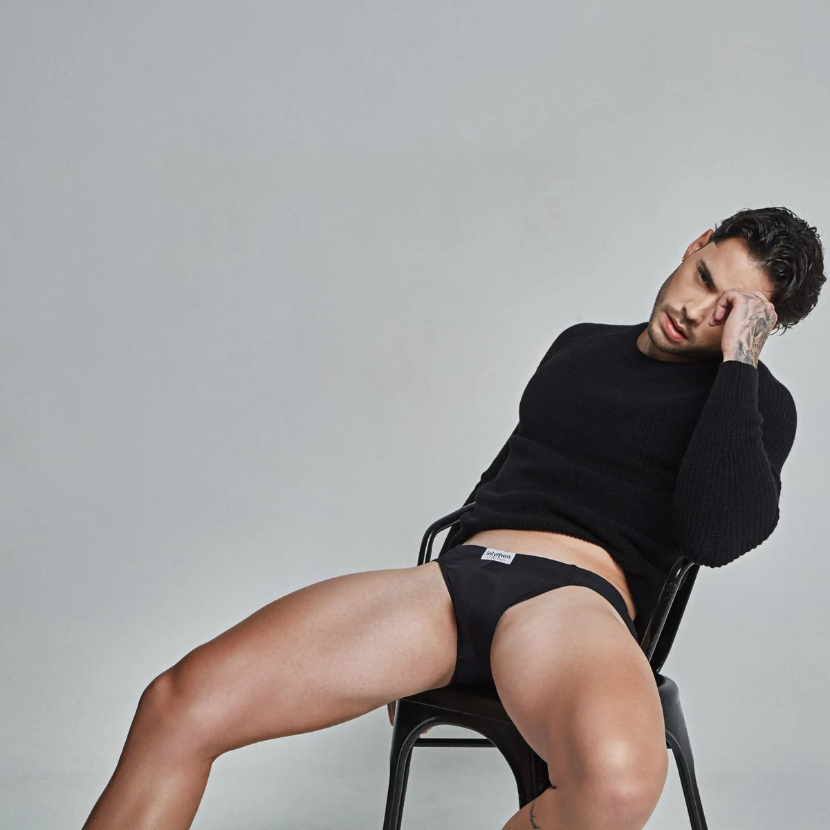 Black cotton briefs with a white Intymen brand label on the waistband for comfortable everyday wear
