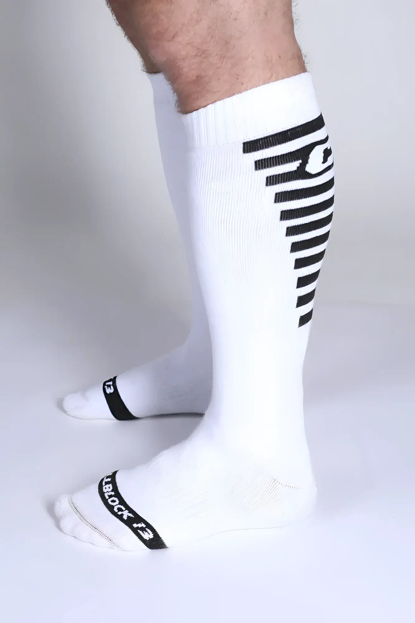 White athletic knee high socks with black diagonal stripes and tiblock 13 branding on the side iron grip knee high sock