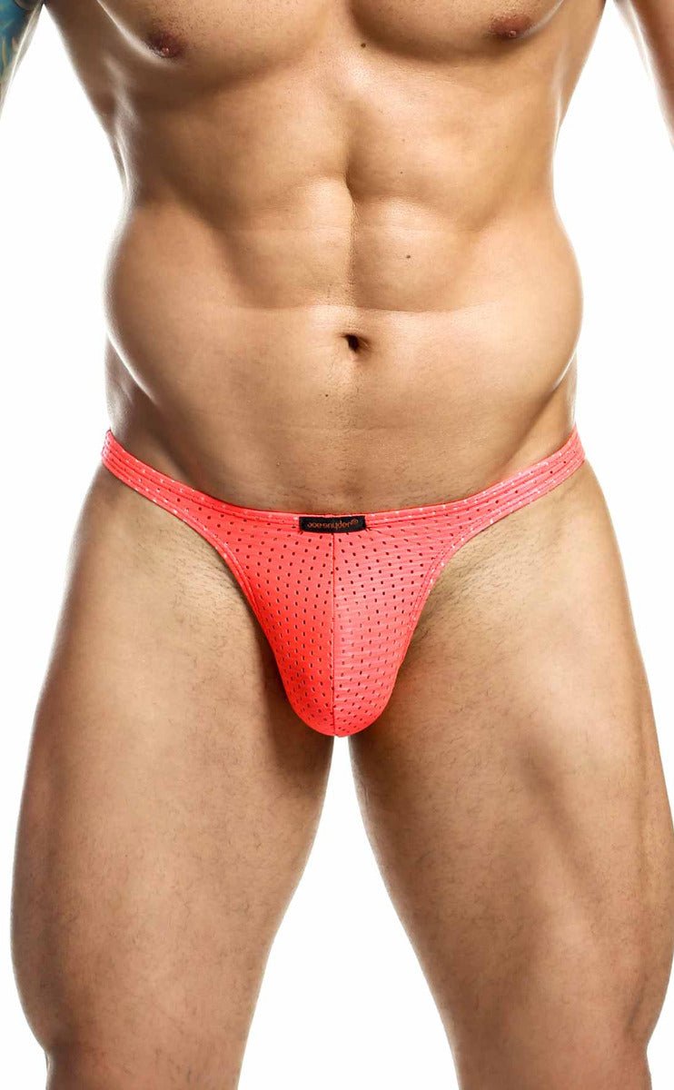 Bright coral pink joe snyder holes thong mesh briefs with subtle perforated texture and black brand tag at waistband