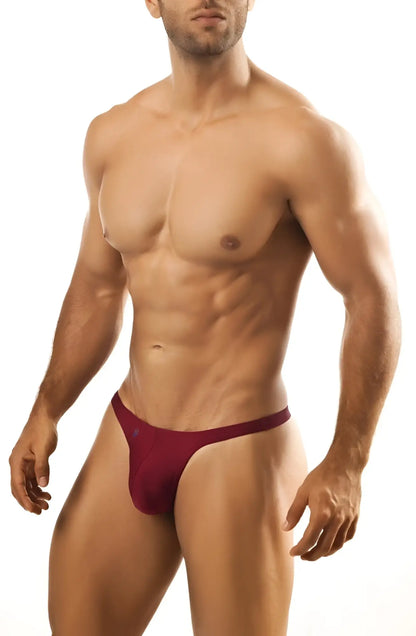 A maroon joe snyder thong made of smooth fabric with a narrow waistband and minimal coverage shown from the back