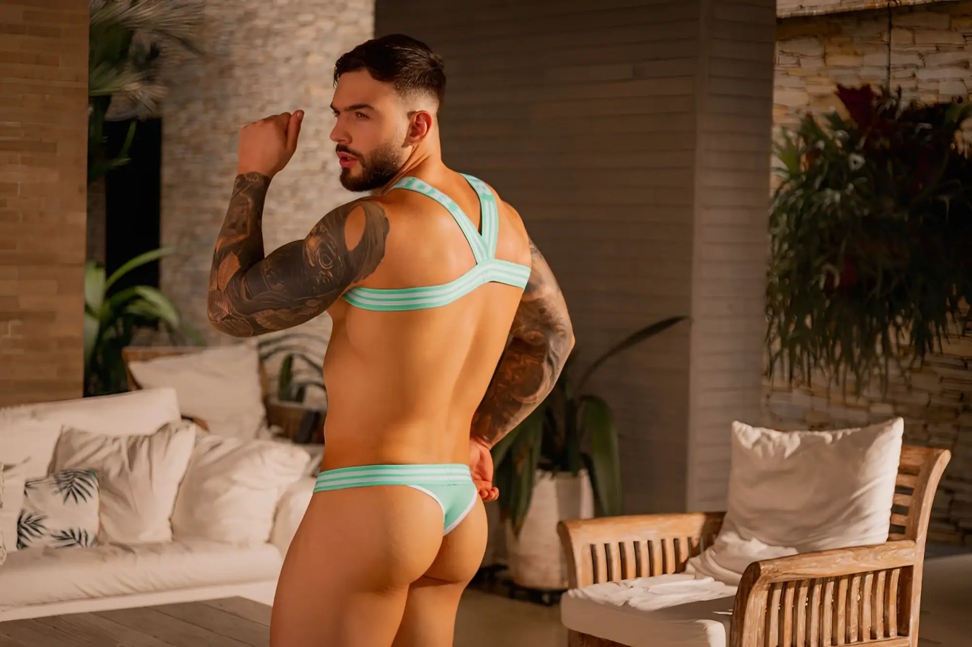 A man wearing jor 2323 college thongs in mint with thin fabric straps and a snug fit bikini-style design