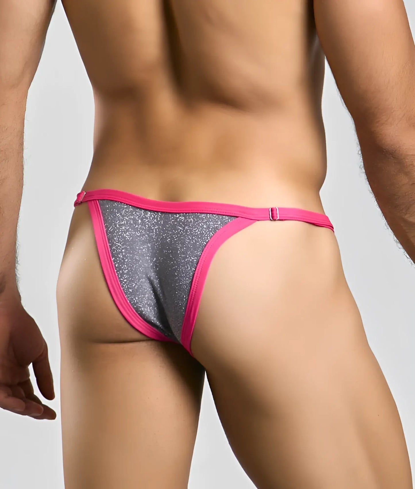 A vibrant pink and silver glitter thong from the justin + simon bikini one with a snug form-fitting design