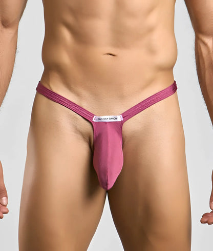 A magenta form-fitting bulge thong with central pouch and white justin + simon label for men