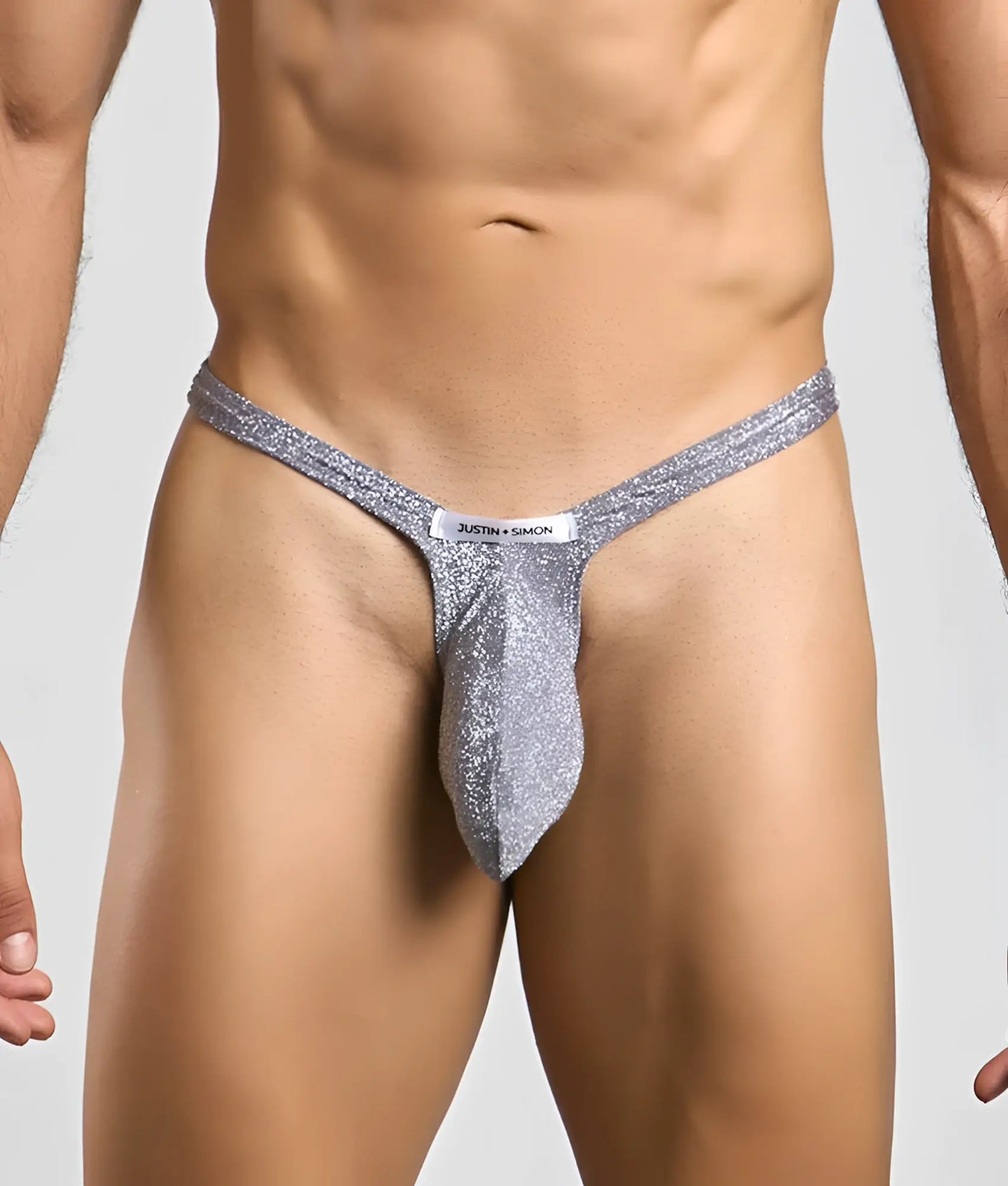 Silver glittery bulge thong with white justin plus simon label at the front for men