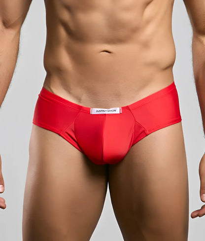 Red justin simon cheek briefs with a smooth form-fitting design and white label at the waistband