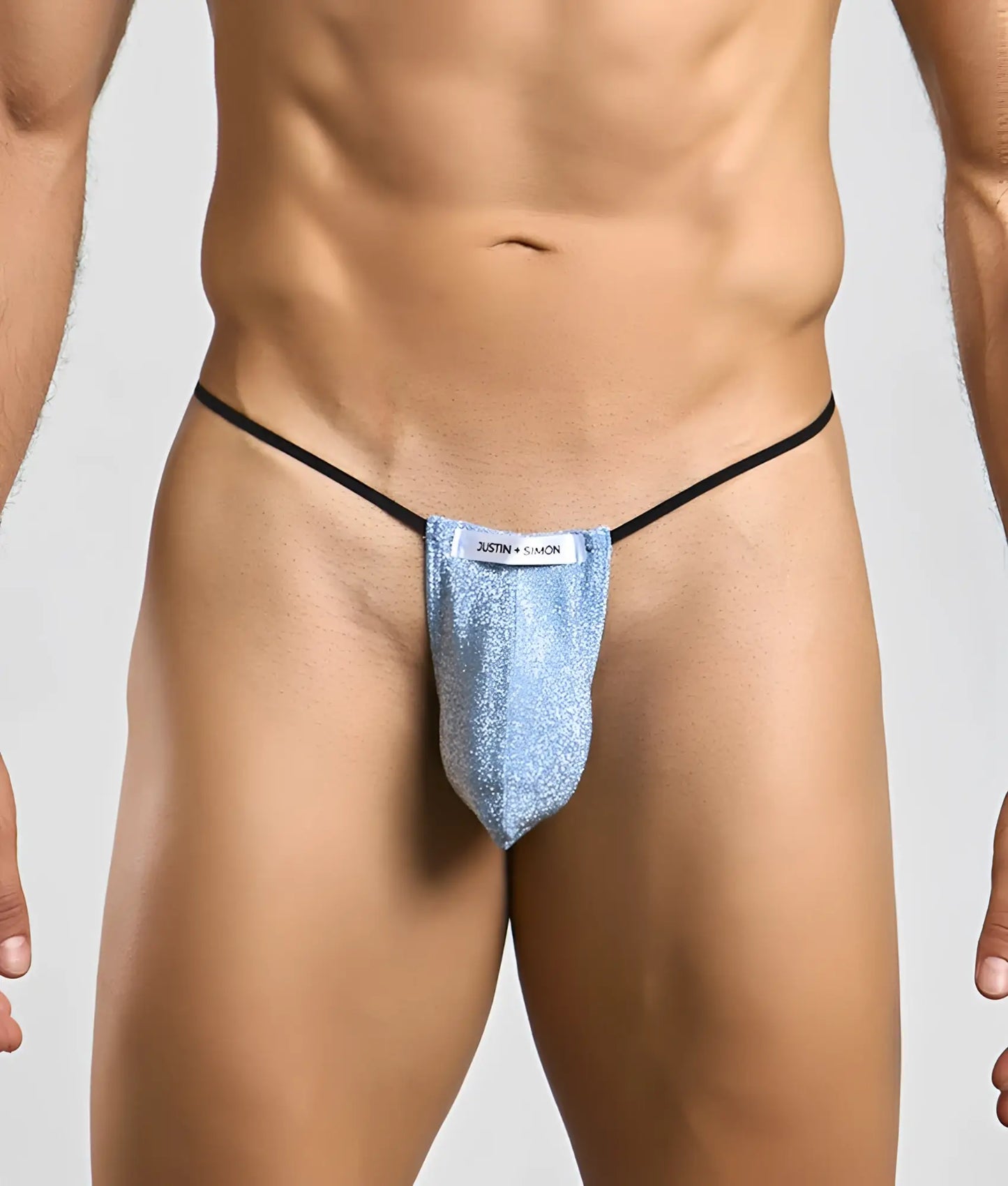 Justin + Simon classic g-string bulge in shimmering light blue glitter with black elastic straps and white label visible