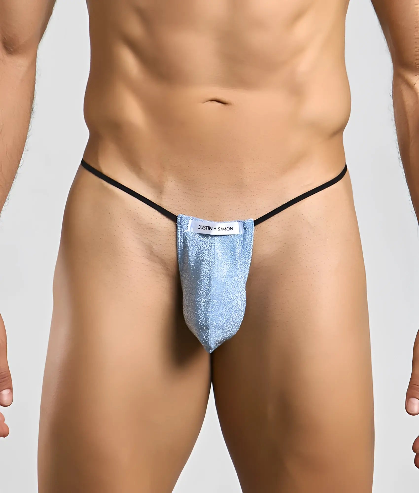 Justin + Simon classic g-string bulge in shimmering light blue glitter with black elastic straps and white label visible