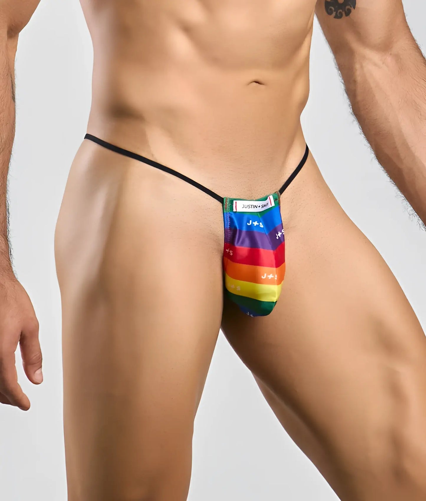 Rainbow-striped fabric thong with black elastic waistband and justin brand label in classic g-string bulge style