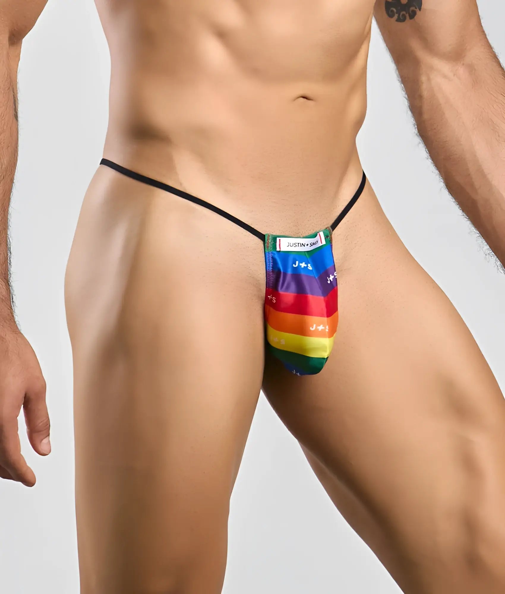 Rainbow-striped fabric thong with black elastic waistband and justin brand label in classic g-string bulge style