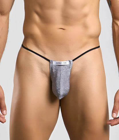 Silver glittery thong g-string with black elastic waistband and justin simon label from the classic bulge line