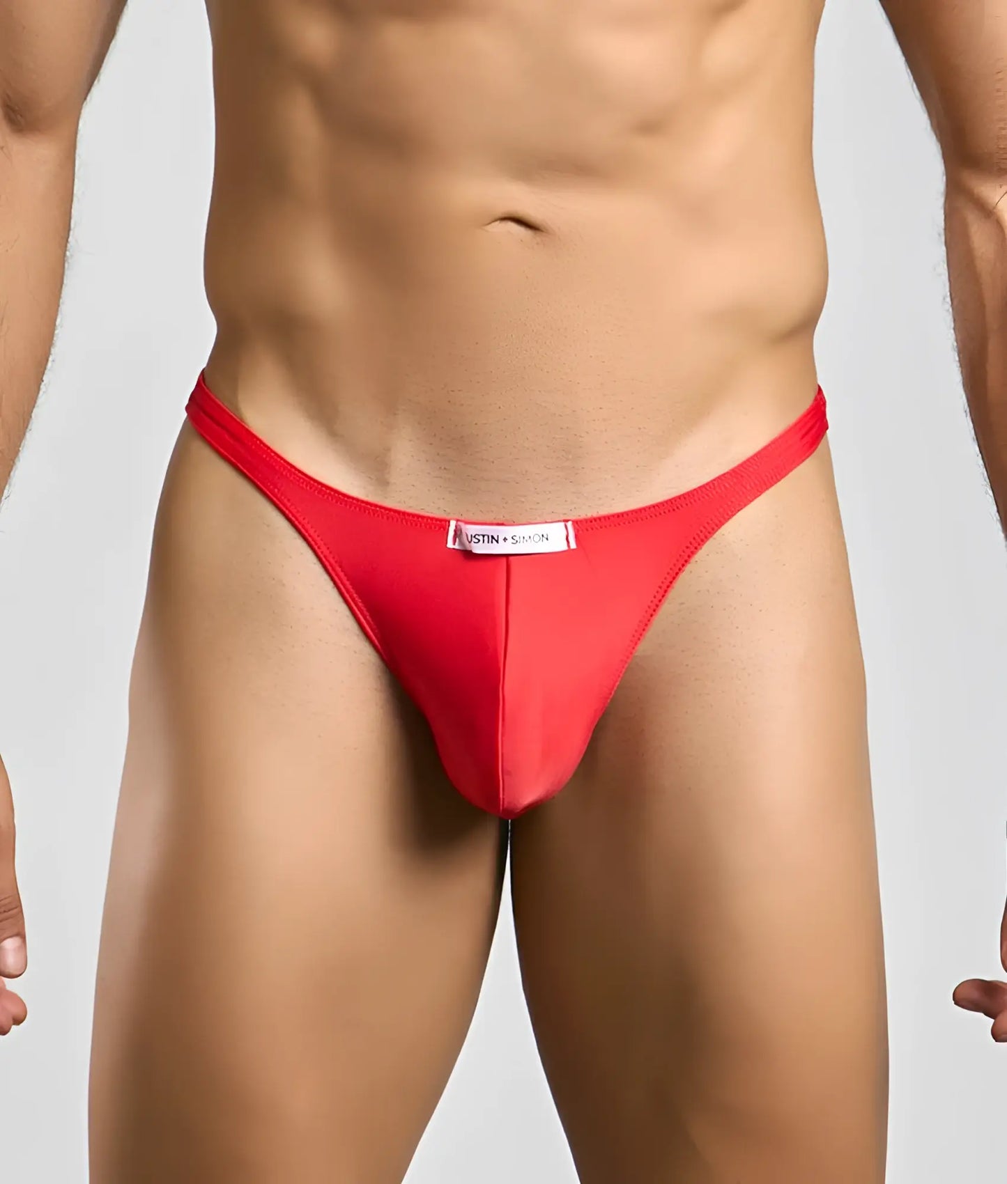 Red thong classic tanga by justin + simon with a white label at the waistband showing the back side