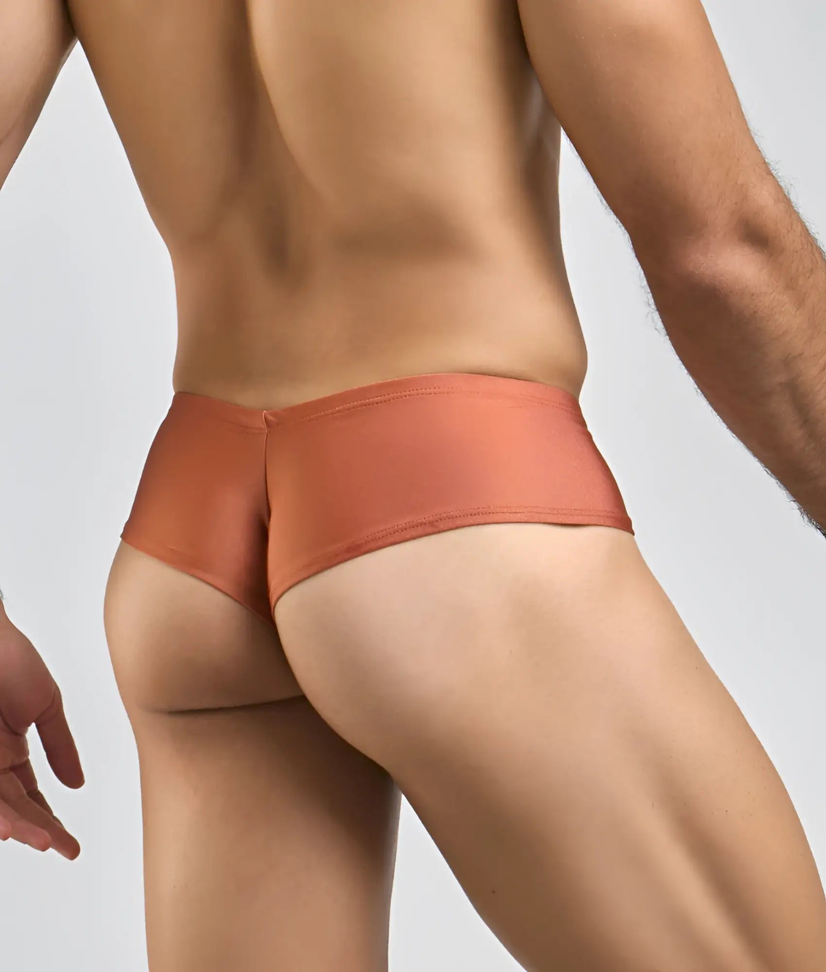 Coral-colored sleek-fitting mens briefs by justin + simon made of smooth stretchy fabric for comfortable wear