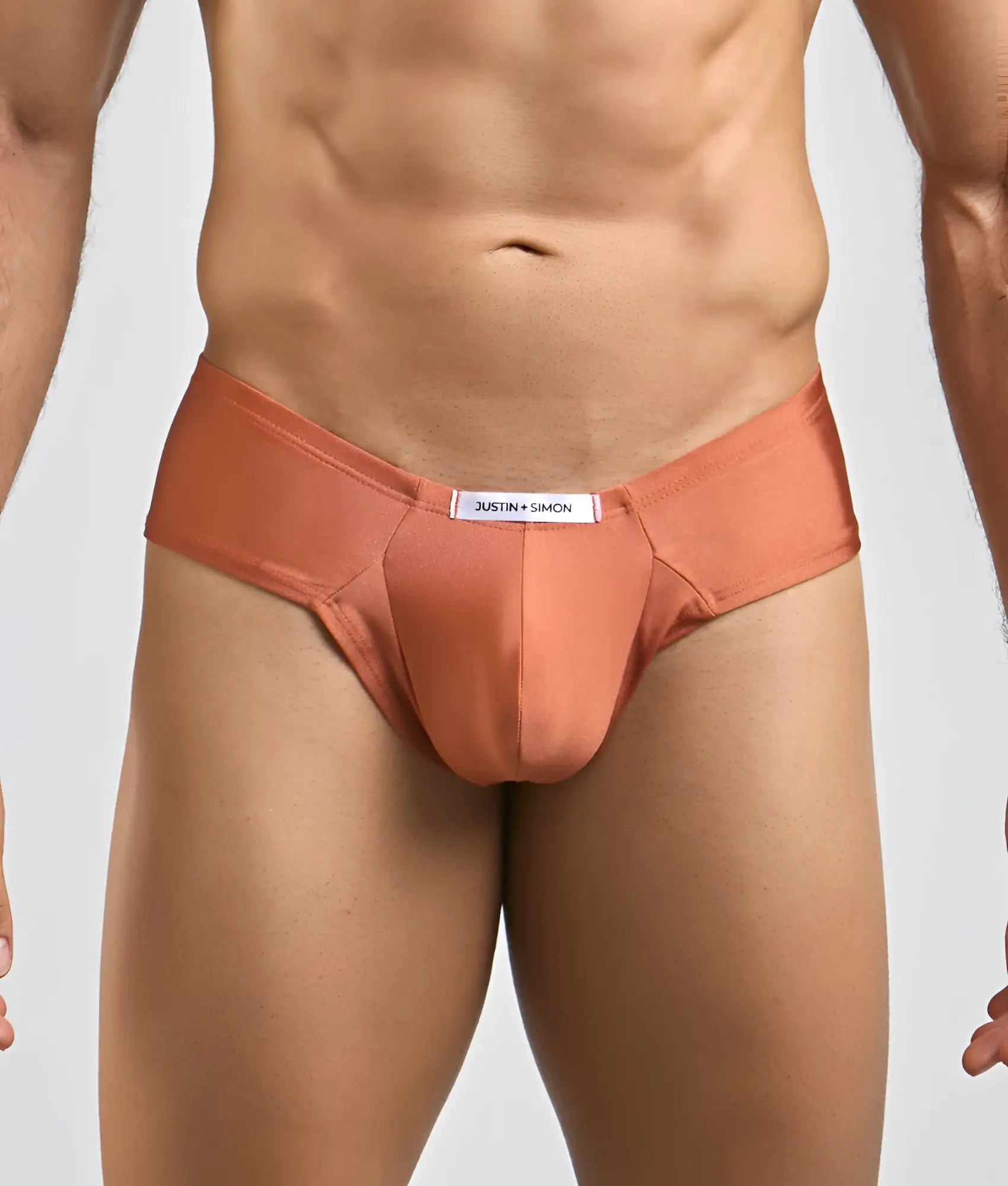 Coral-colored smooth textured men’s briefs with branded waistband label from Justin + Simon cheek collection