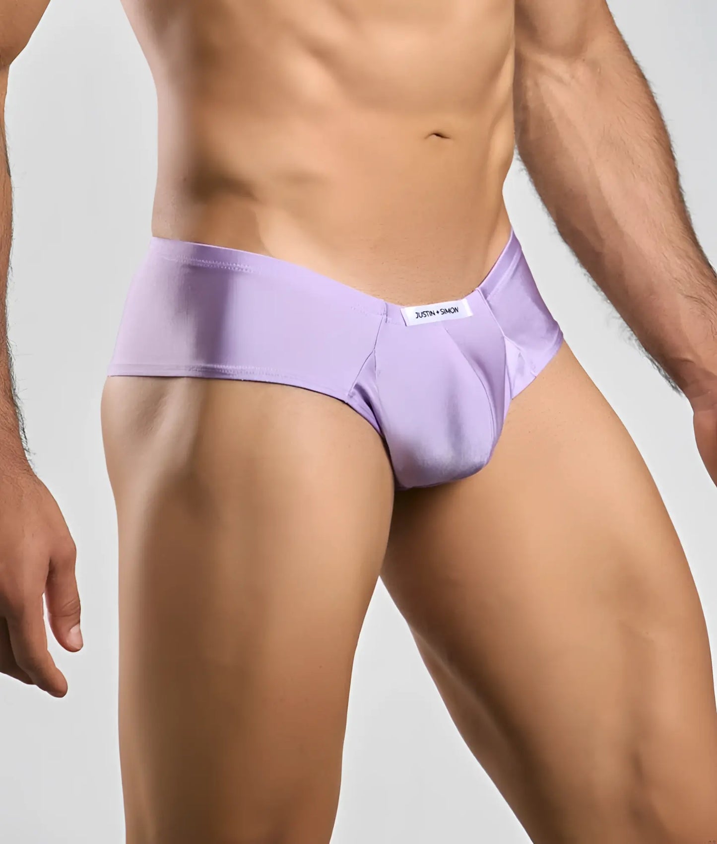 Lavender-colored smooth-textured briefs with a white brand tag on the waistband from justin + simon cheek collection